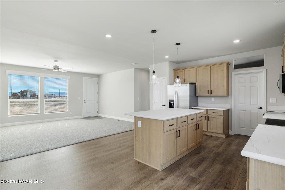 7366 East Bunkhouse Road Prescott Valley, AZ 86315 - Photo 15 of 25 a kitchen with a stove a sink a refrigerator and white cabinets with wooden floor