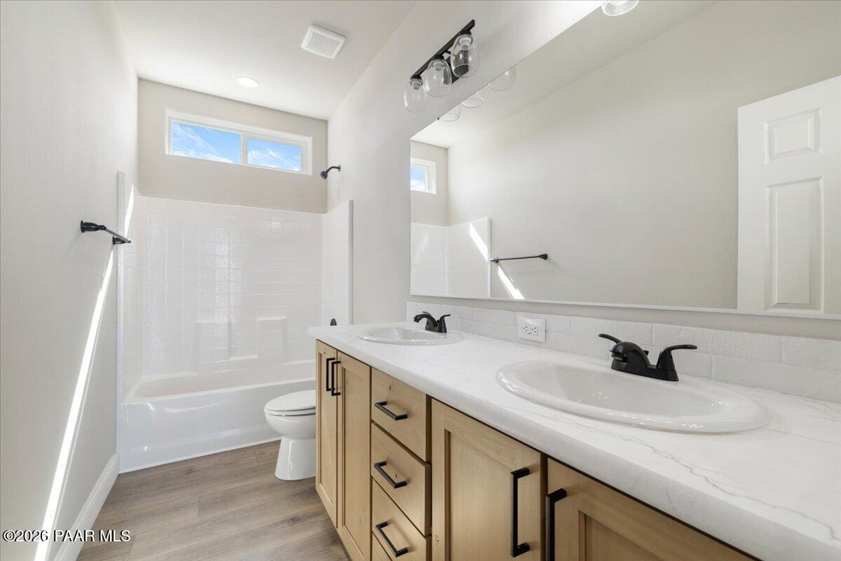 7366 East Bunkhouse Road Prescott Valley, AZ 86315 - Photo 24 of 25 a bathroom with a double vanity sink toilet mirror and bathtub