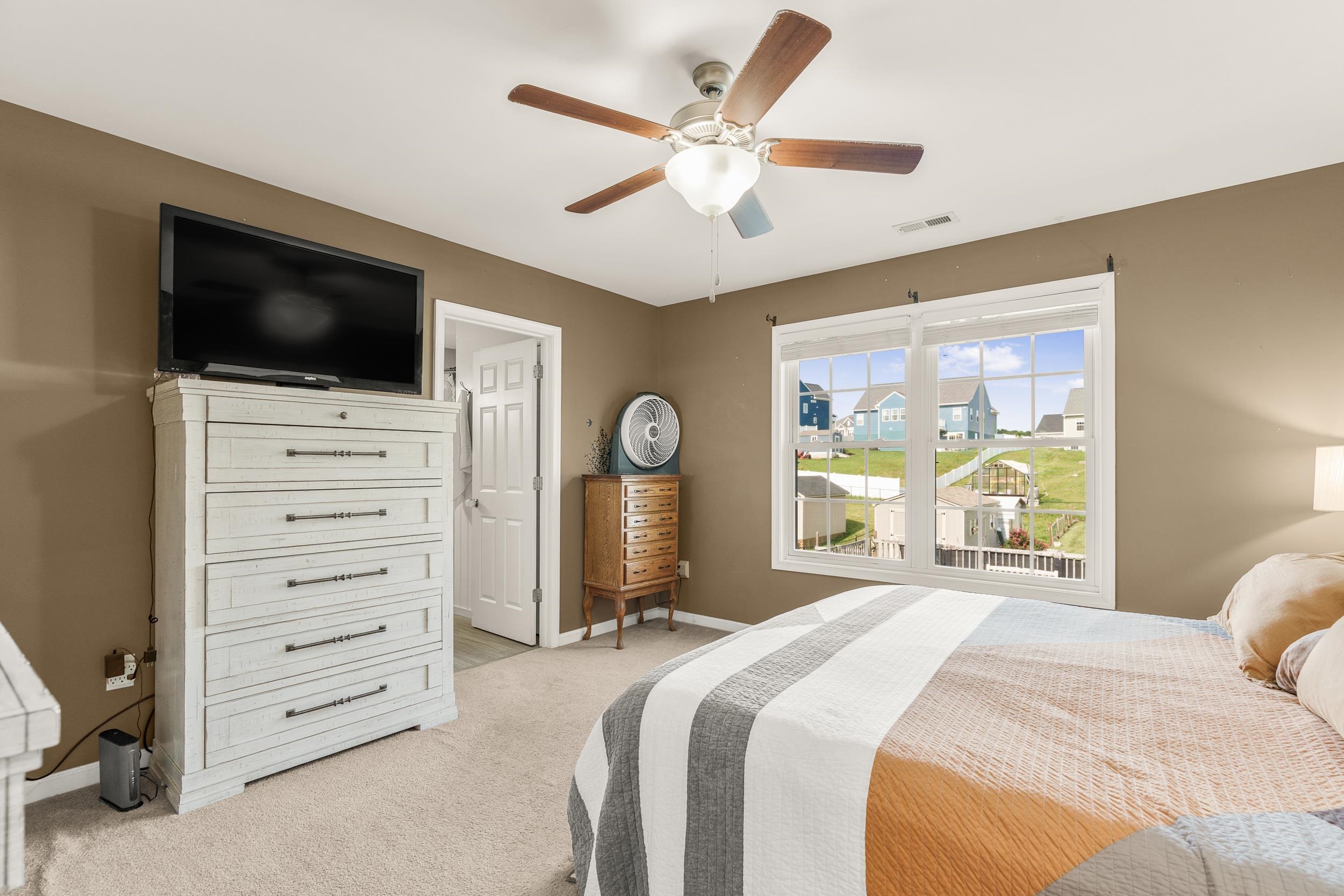 96 Lofty Circle Stuarts Draft, VA 24477 - Photo 20 of 69 a bedroom with a large bed and a flat tv screen on dresser