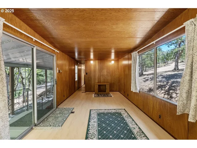a living room with furniture a flat screen tv and a floor to ceiling window