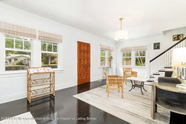 a living room with furniture a dining table and a large window