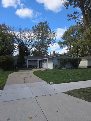 a view of a house with a yard and a large tree