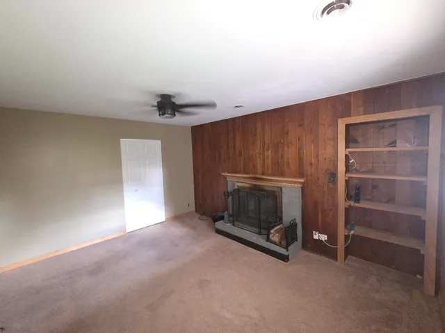 a view of empty room with a fireplace and window