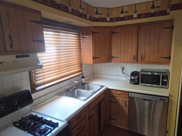 a kitchen with stainless steel appliances granite countertop a sink stove and cabinets