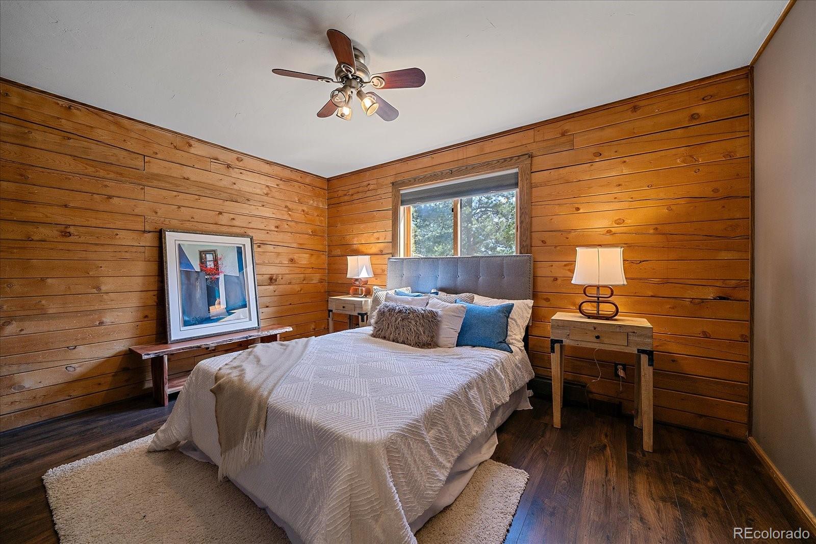 1385 Beaver Brook Canyon Road Evergreen, CO 80439 - Photo 17 of 49 a bedroom with a bed and a chandelier