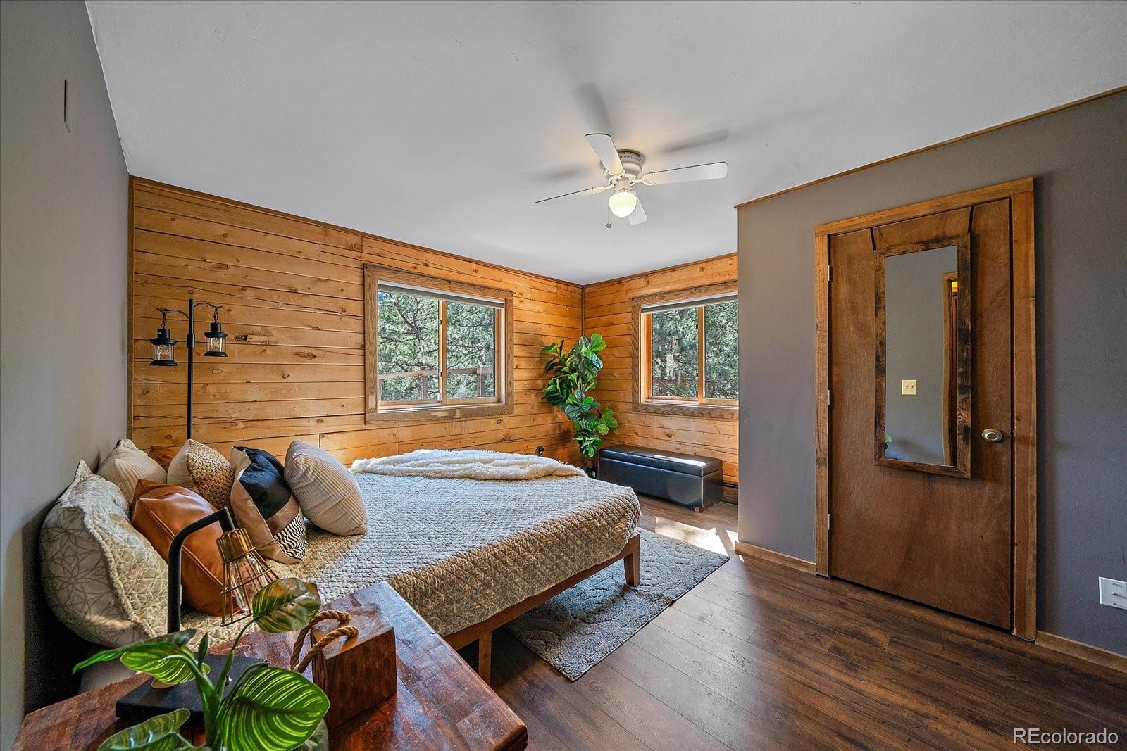 1385 Beaver Brook Canyon Road Evergreen, CO 80439 - Photo 18 of 49 a spacious bedroom with a bed and wooden floor