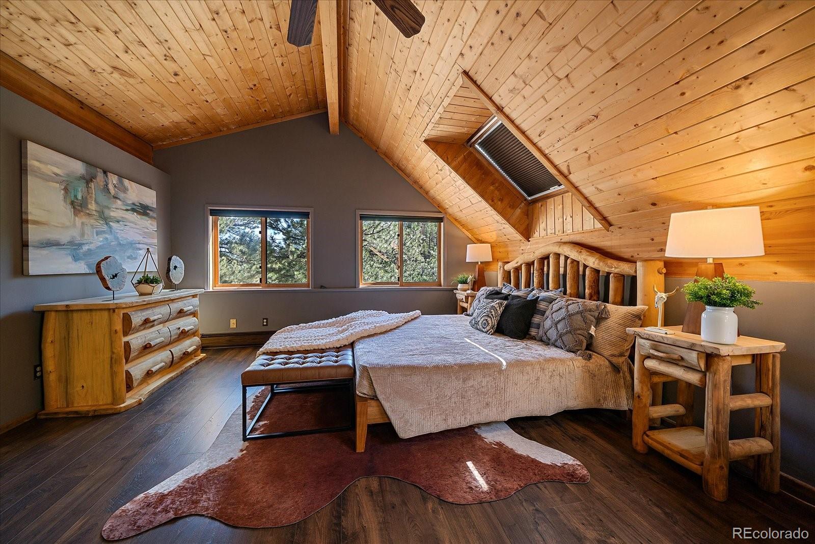 1385 Beaver Brook Canyon Road Evergreen, CO 80439 - Photo 24 of 49 a bedroom with a bed wooden floor and window