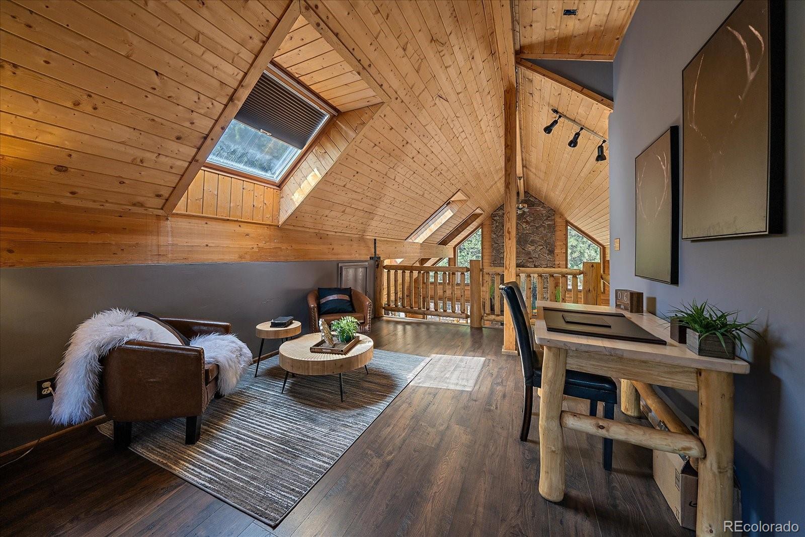 1385 Beaver Brook Canyon Road Evergreen, CO 80439 - Photo 25 of 49 a view of a balcony with chairs and wooden floor