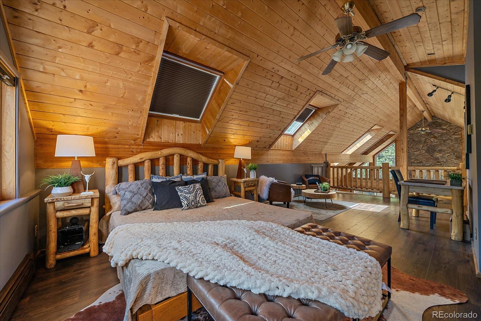 1385 Beaver Brook Canyon Road Evergreen, CO 80439 - Photo 26 of 49 a bedroom with bed and wooden floor