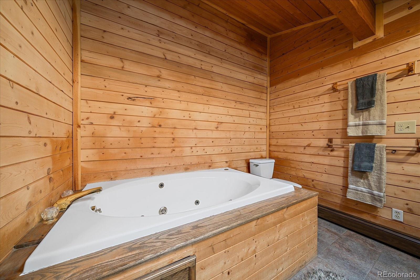 1385 Beaver Brook Canyon Road Evergreen, CO 80439 - Photo 29 of 49 a bathroom with a bathtub and shower