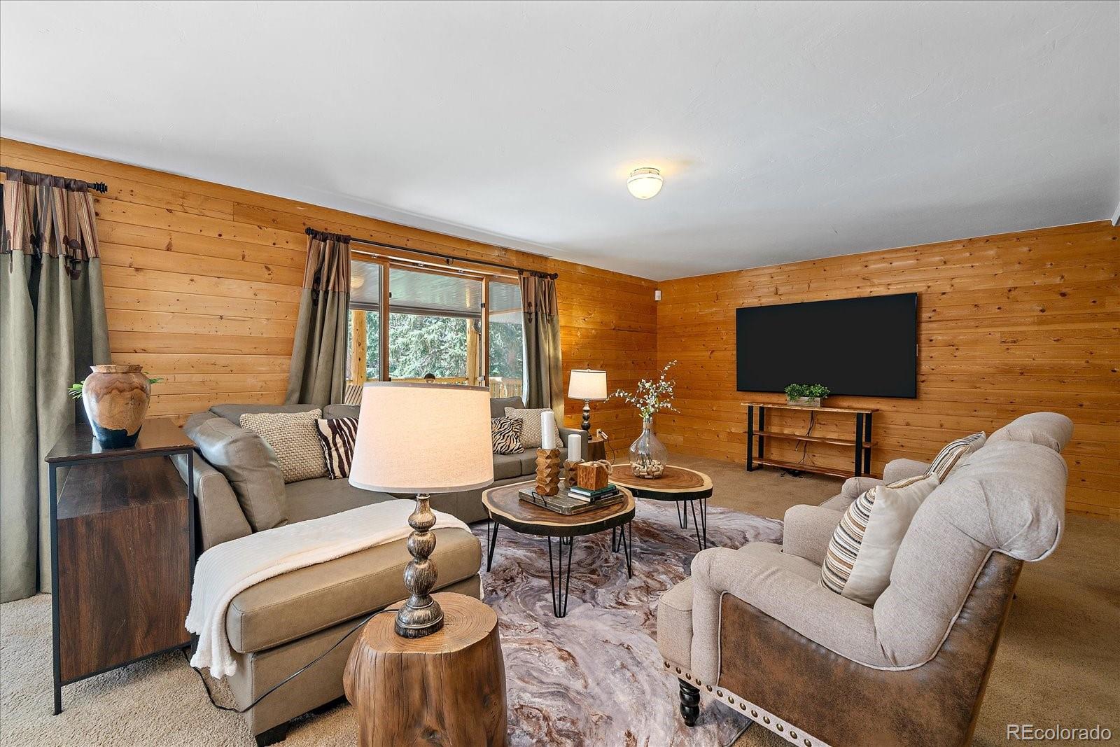 1385 Beaver Brook Canyon Road Evergreen, CO 80439 - Photo 31 of 49 a living room with furniture and a flat screen tv