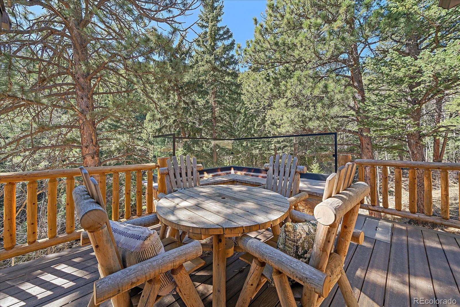 1385 Beaver Brook Canyon Road Evergreen, CO 80439 - Photo 35 of 49 a view of a balcony with table and chairs