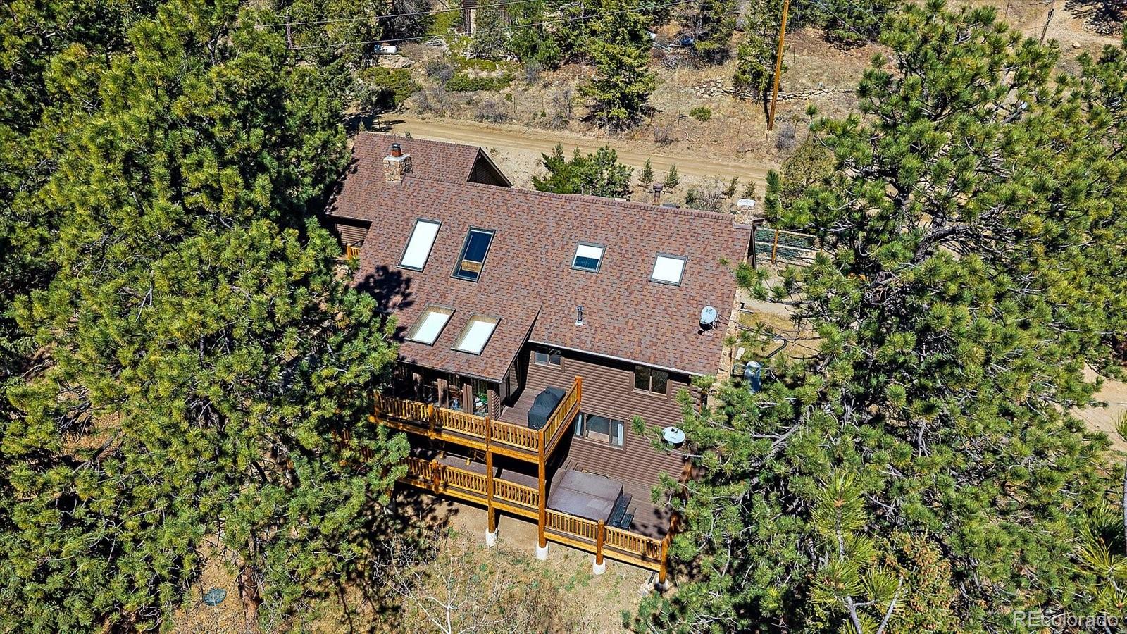 1385 Beaver Brook Canyon Road Evergreen, CO 80439 - Photo 36 of 49 an aerial view of a house with backyard and outdoor seating