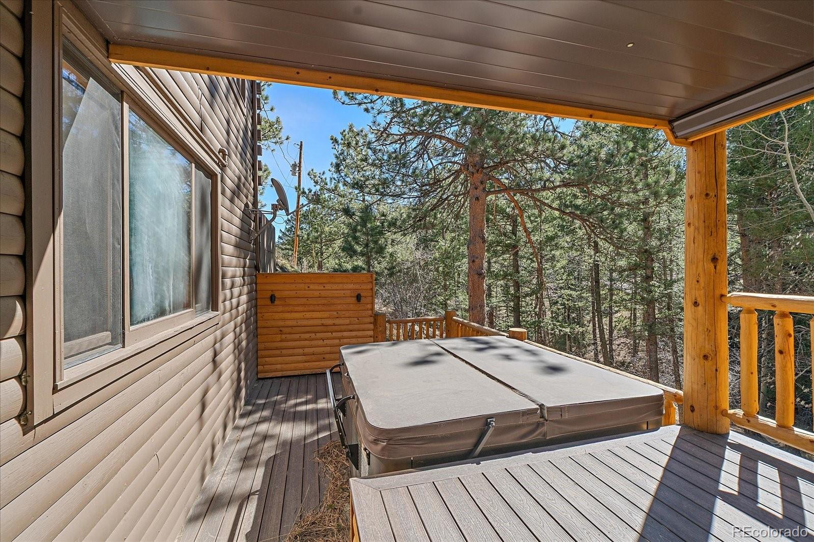 1385 Beaver Brook Canyon Road Evergreen, CO 80439 - Photo 40 of 49 a view of a balcony with chairs and wooden floor