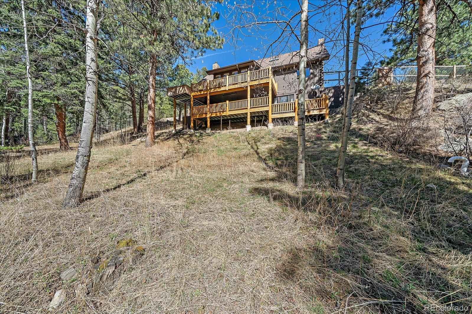 1385 Beaver Brook Canyon Road Evergreen, CO 80439 - Photo 43 of 49 a view of a house with a yard