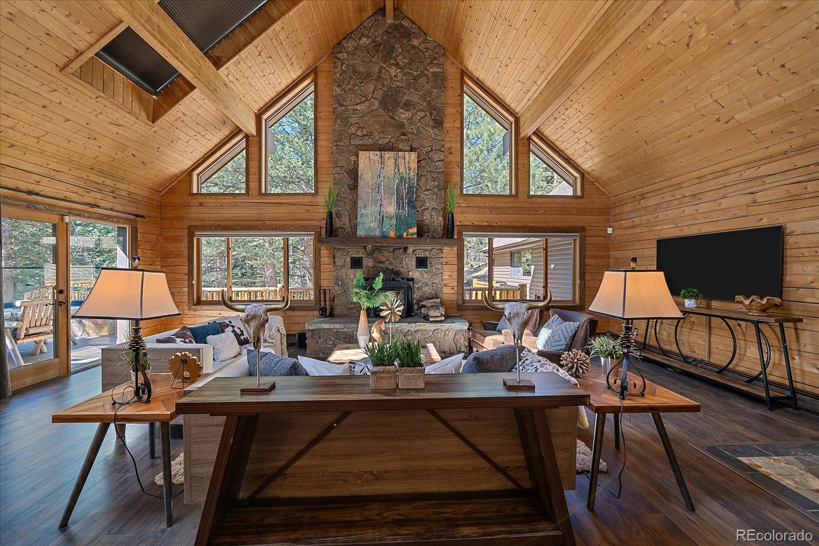 1385 Beaver Brook Canyon Road Evergreen, CO 80439 - Photo 8 of 49 a living room with furniture a fireplace and a flat screen tv