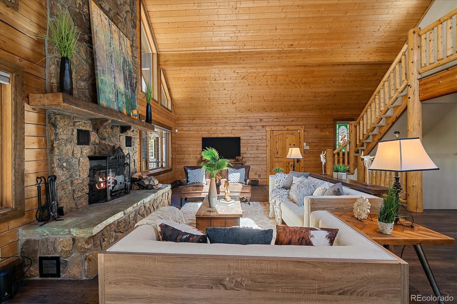 1385 Beaver Brook Canyon Road Evergreen, CO 80439 - Photo 9 of 49 a view of a living room with furniture and a fireplace