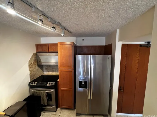 a metallic refrigerator freezer sitting in a kitchen