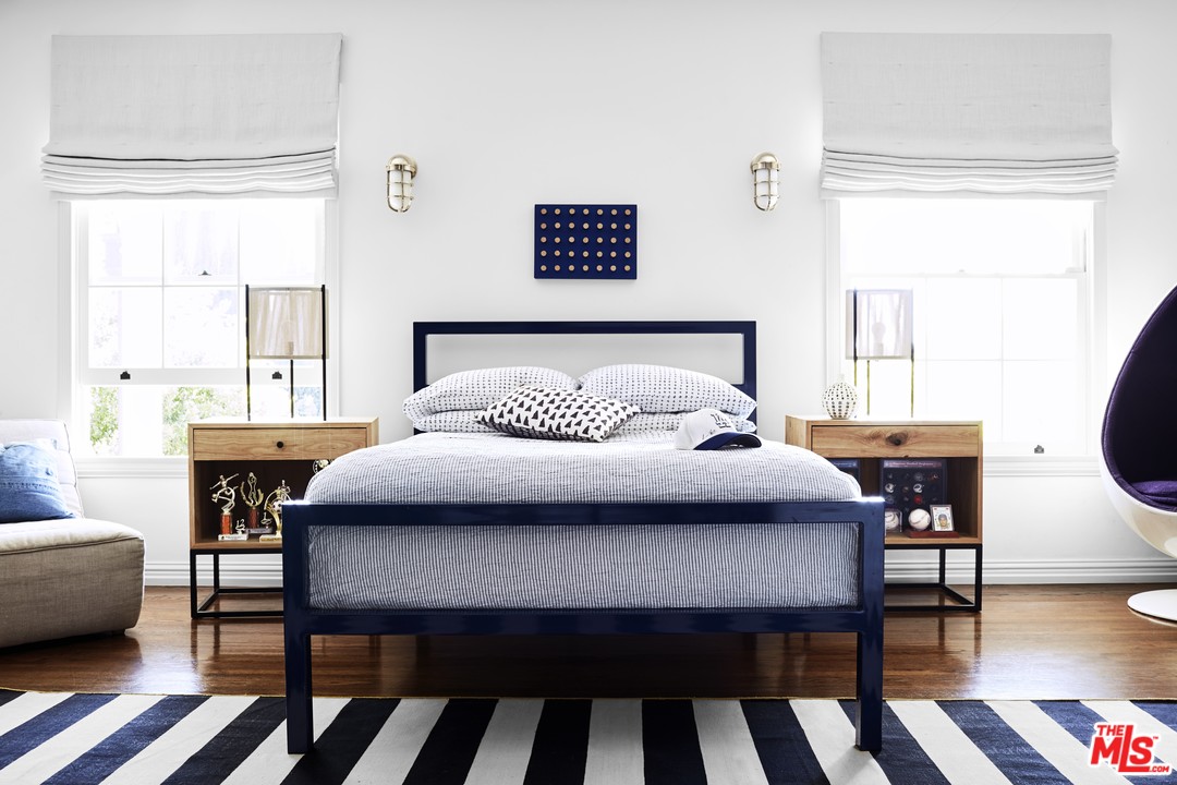 555 South Rimpau Boulevard Los Angeles, CA 90020 - Photo 12 of 17 a bedroom with a bed a table and a dresser next to a window