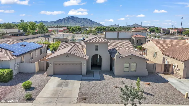 a front view of a house with a yard and potted plants