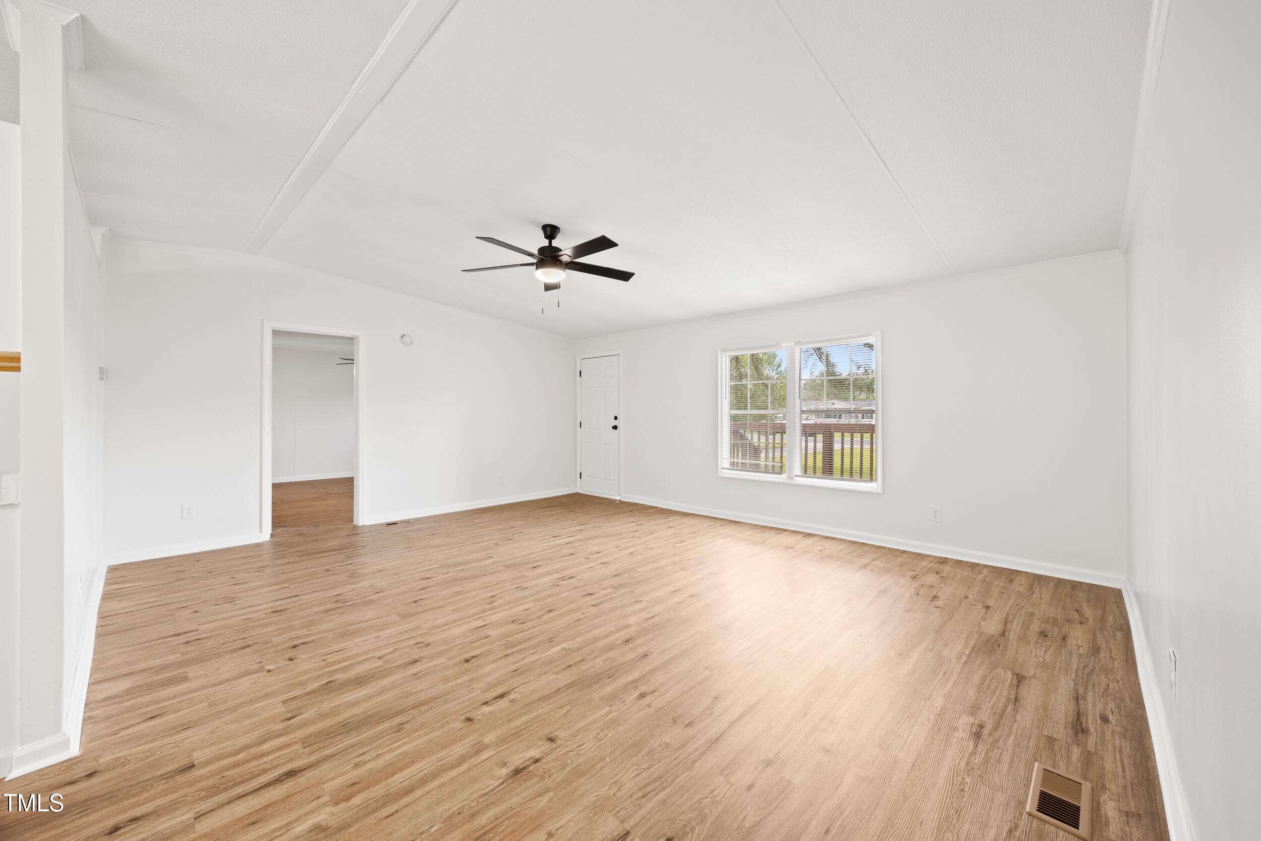6423 Sandy Creek Road Stedman, NC 28391 - Photo 12 of 40 a view of an empty room with wooden floor and a window