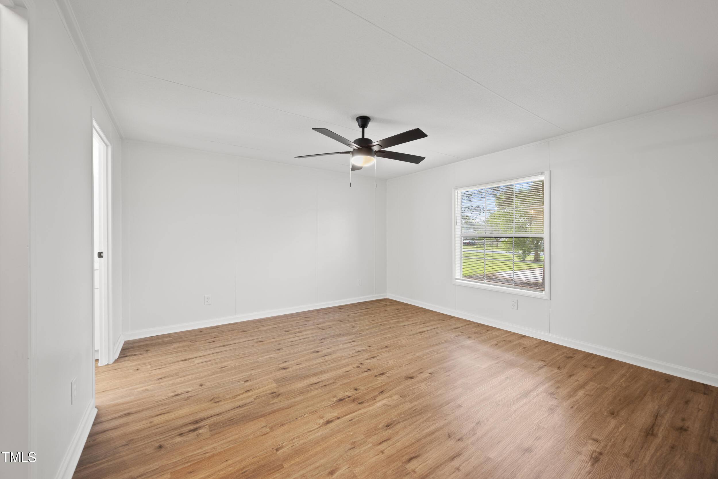 6423 Sandy Creek Road Stedman, NC 28391 - Photo 13 of 40 an empty room with wooden floor and windows