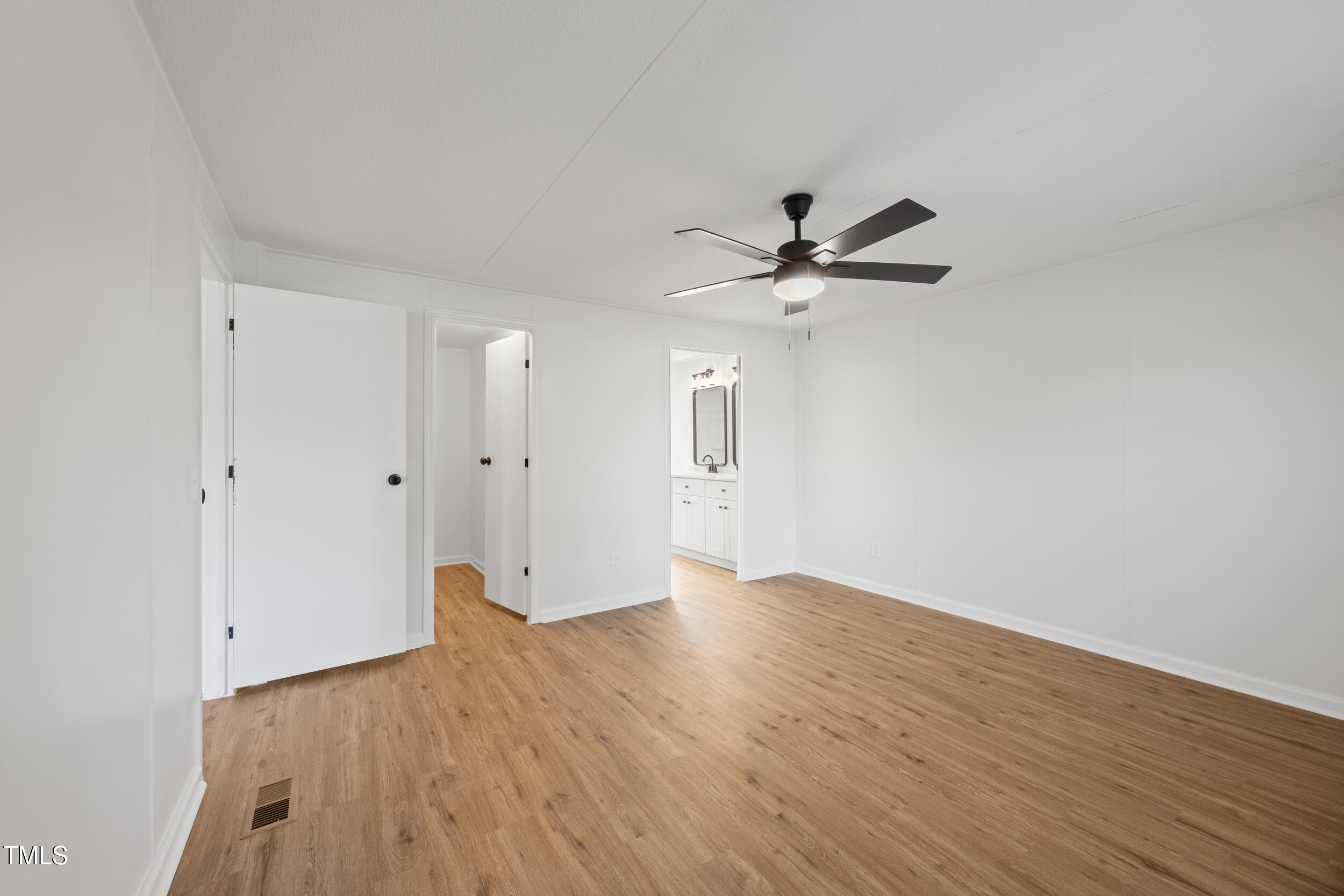 6423 Sandy Creek Road Stedman, NC 28391 - Photo 14 of 40 an empty room with wooden floor and a ceiling fan