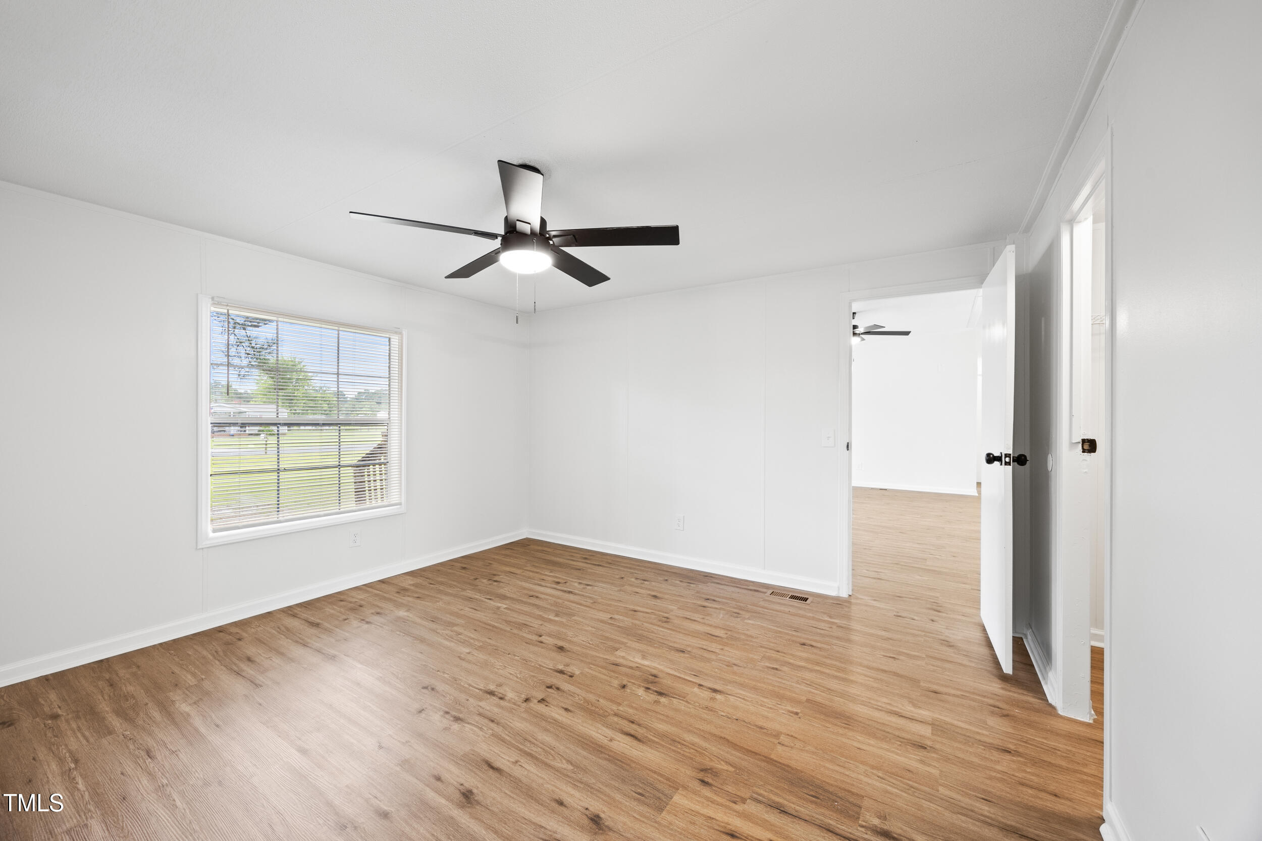 6423 Sandy Creek Road Stedman, NC 28391 - Photo 16 of 40 a view of an empty room with wooden floor and a window