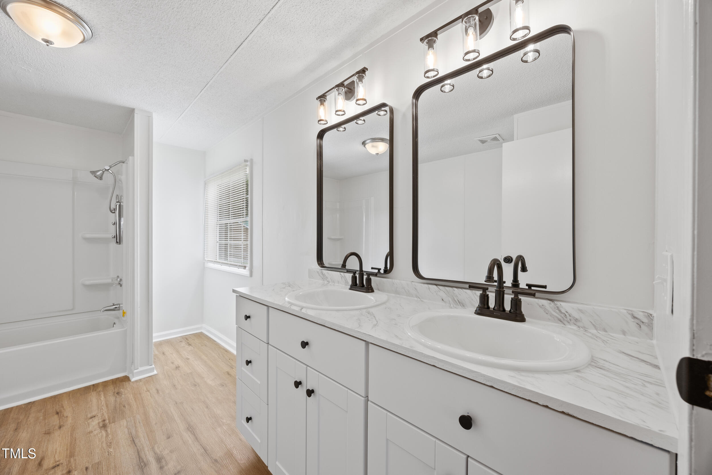 6423 Sandy Creek Road Stedman, NC 28391 - Photo 17 of 40 a bathroom with a double vanity sink mirror and shower