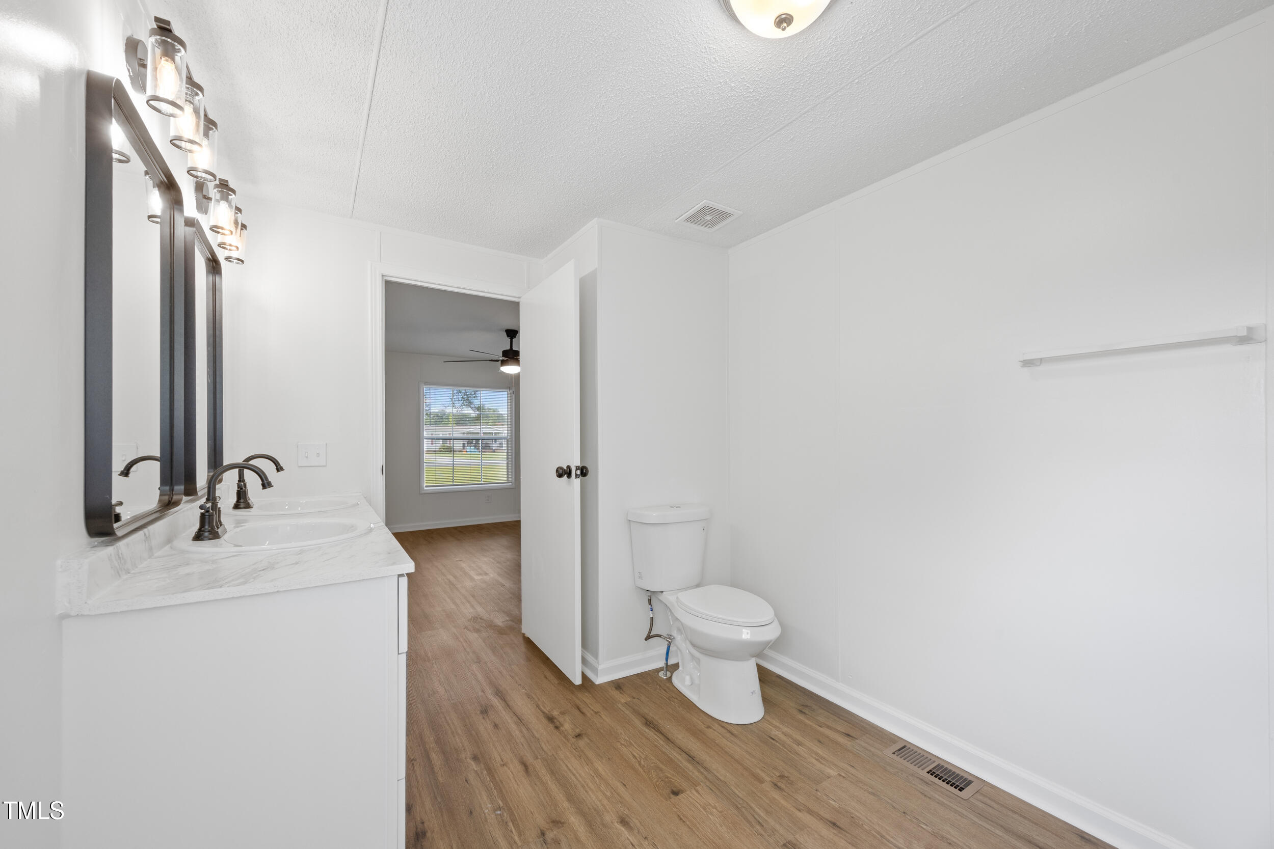 6423 Sandy Creek Road Stedman, NC 28391 - Photo 18 of 40 a bathroom with a sink toilet a mirror and vanity