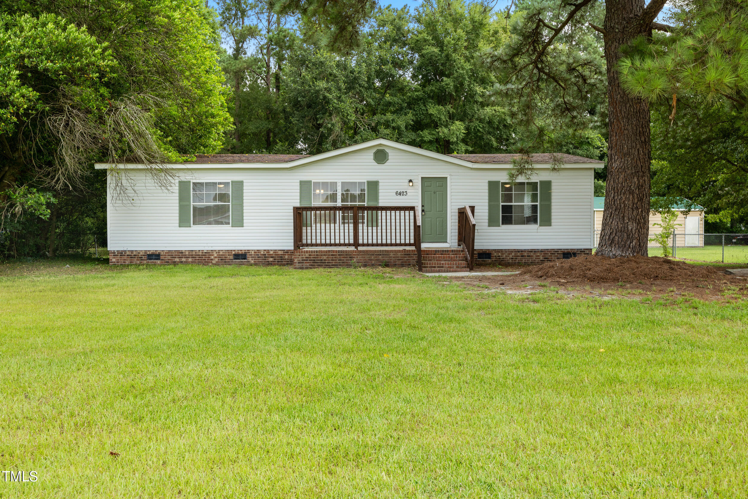 6423 Sandy Creek Road Stedman, NC 28391 - Photo 2 of 40 a backyard of a house with table and chairs