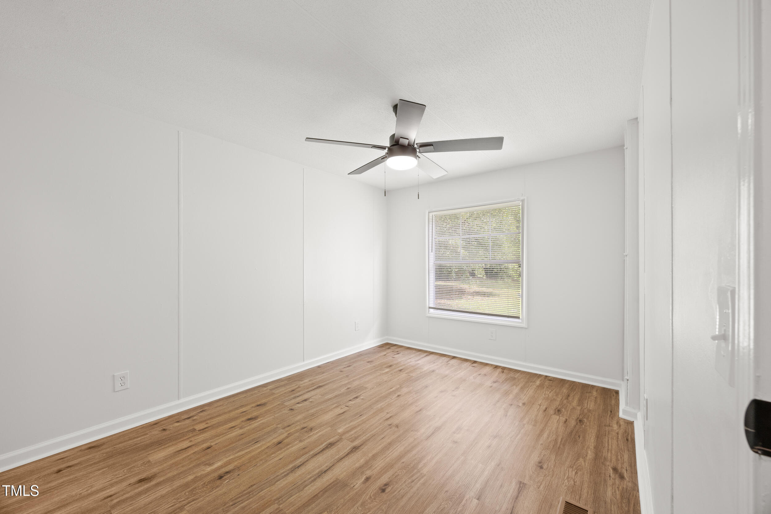 6423 Sandy Creek Road Stedman, NC 28391 - Photo 26 of 40 a view of an empty room with wooden floor and a window