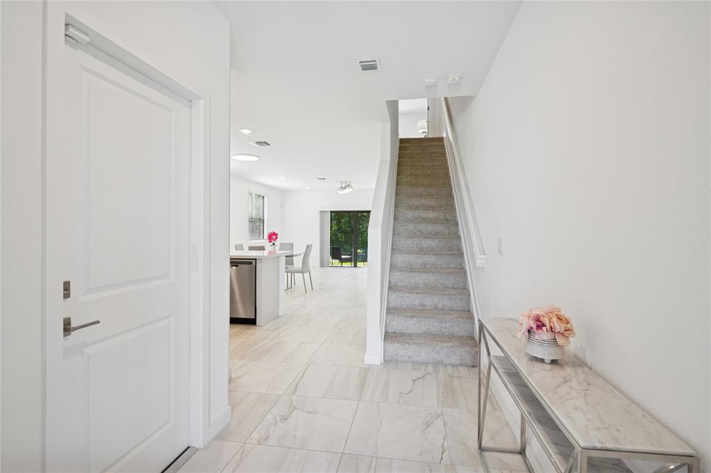 180 Southeast 5th Court Deerfield Beach, FL 33441 - Photo 6 of 25 a room with a table and a chandelier