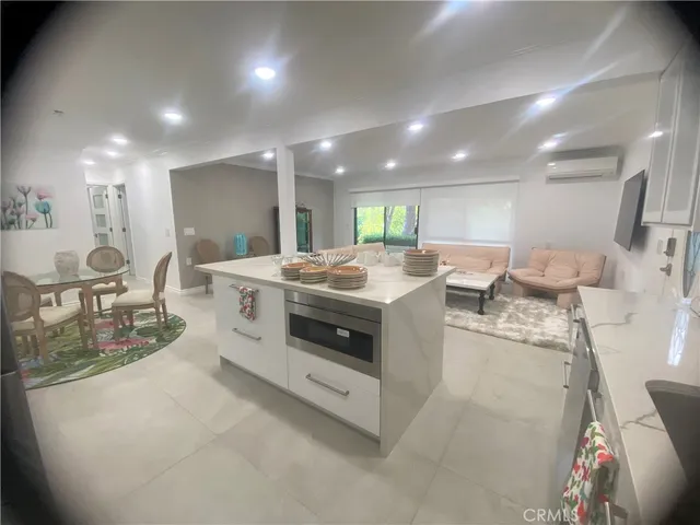 a kitchen with stainless steel appliances a sink a stove a table and chairs