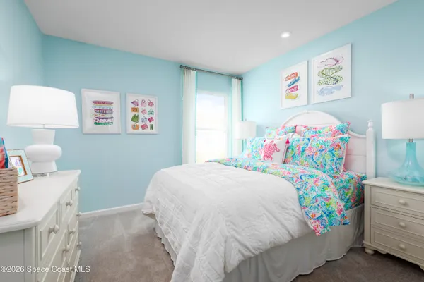 a bedroom with a bed and a lamp on dresser