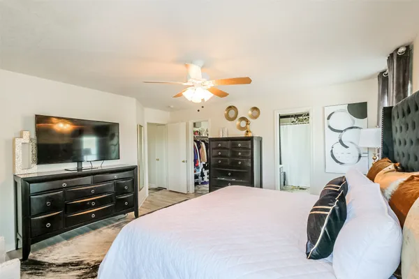 a bedroom with a bed and a flat tv screen on the dresser