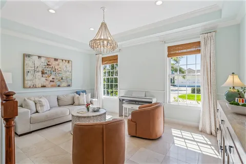 a living room with furniture a chandelier and a dining table