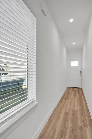 a kitchen with a sink chandelier and wooden floor