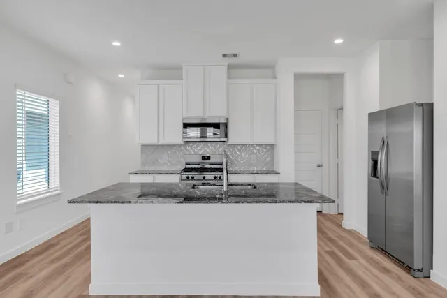 a kitchen with stainless steel appliances granite countertop a refrigerator sink and microwave
