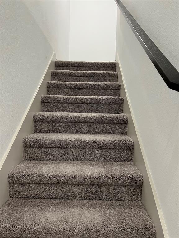6041 Roper Road McKinney, TX 75070 - Photo 13 of 24 Staircase featuring grey plush carpeting and a dark-toned handrail