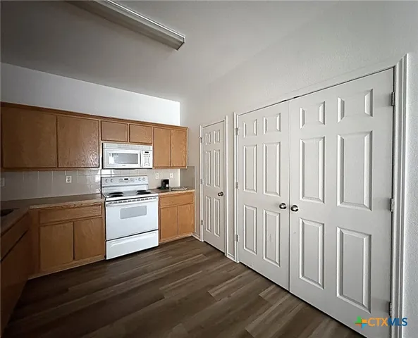 a kitchen with white cabinets and white appliances