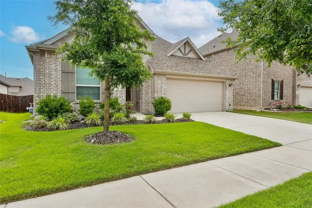 a front view of a house with a garden and plants