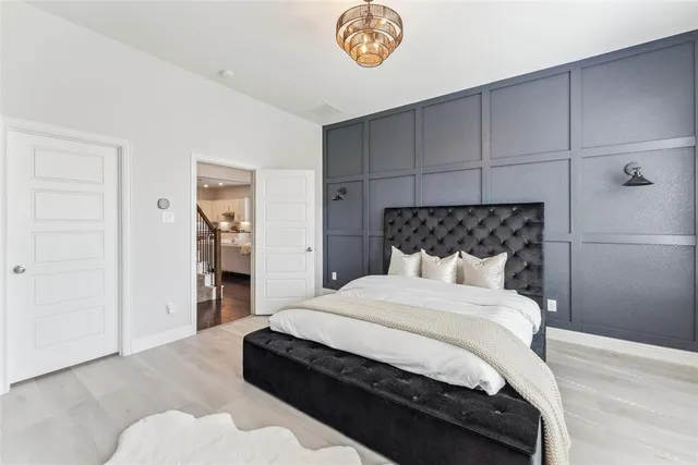 a bedroom with a bed and a chandelier