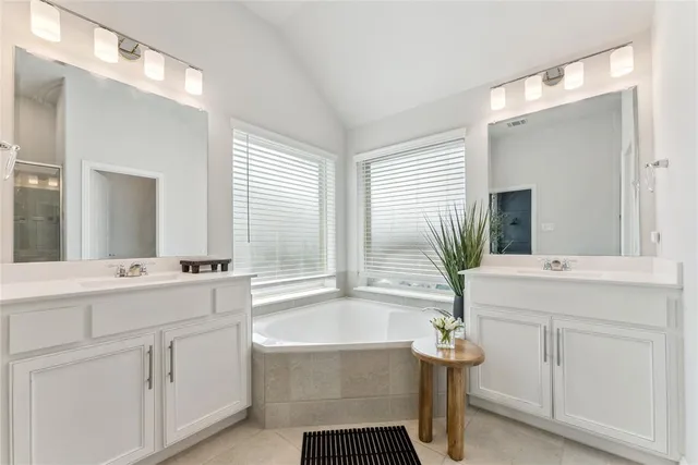 a bathroom with a tub sink and mirror