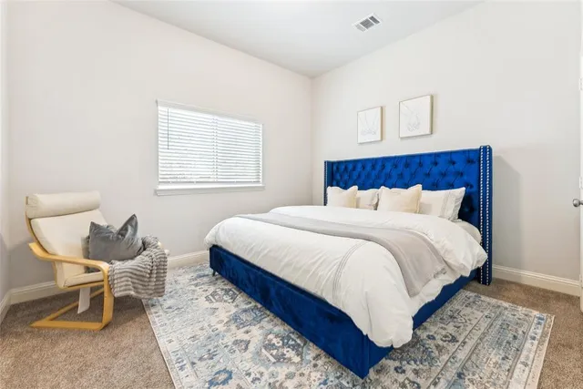 a bed sitting in a bedroom next to a window