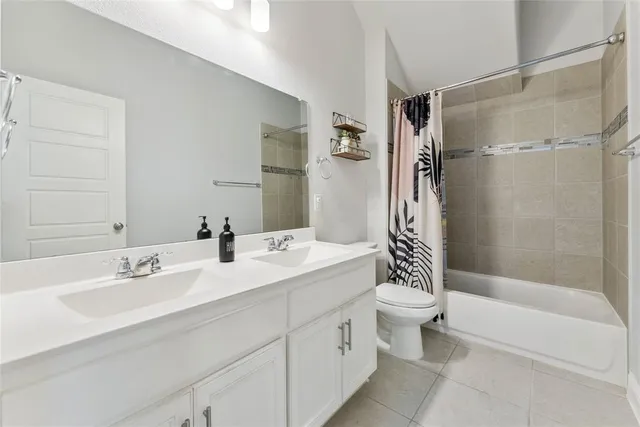 a bathroom with a double vanity sink toilet mirror and shower