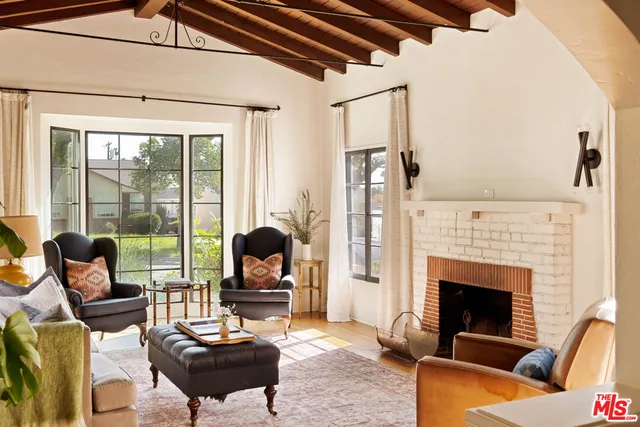 a living room with furniture fireplace and a floor to ceiling window