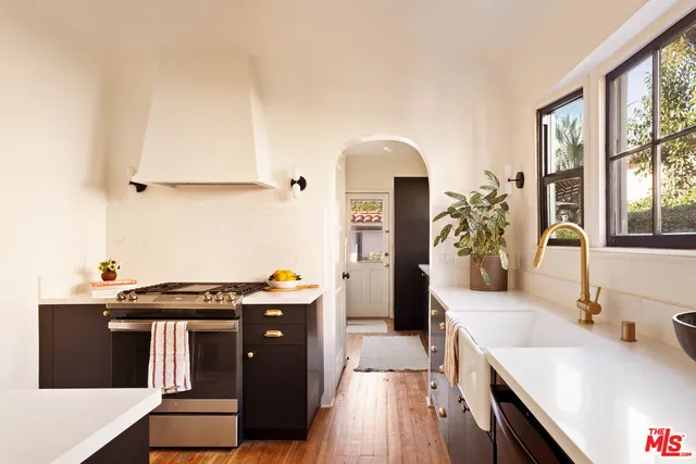 a kitchen with stainless steel appliances granite countertop a stove a sink and a refrigerator