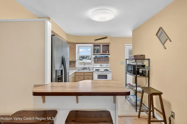 a living room with stainless steel appliances kitchen island granite countertop furniture and a refrigerator