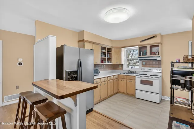 a kitchen with stainless steel appliances a stove a refrigerator and a dining table